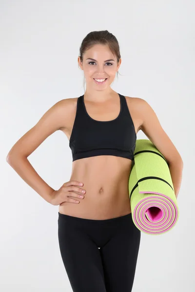 Beautiful young girl with gym mat at home — Stock Photo, Image