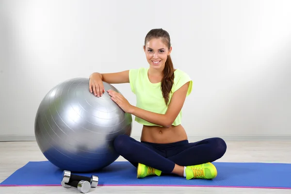 Beautiful young girl with grey ball at home — Stock Photo, Image