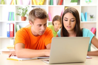 Kütüphanede oturan genç öğrenci grubu