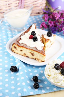 Ahşap masa yakın çekim peçeteye plaka üzerinde kuru üzüm ile peynir güveç