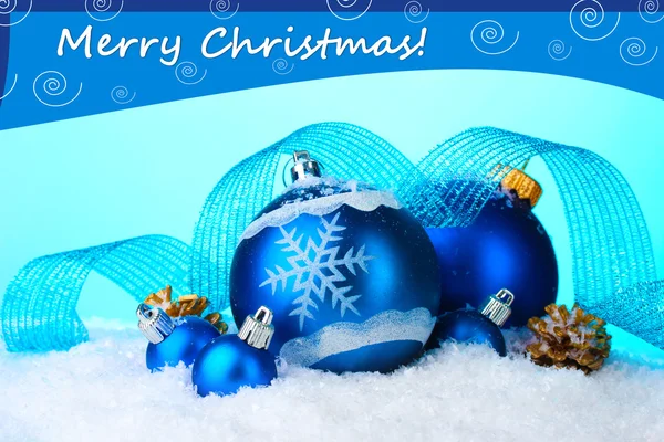 Schöne blaue Weihnachtskugeln im Schnee auf blauem Hintergrund — Stockfoto
