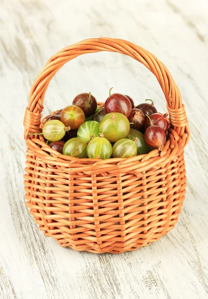 Fresh gooseberries in wicker basket on table close-up — Stock Photo, Image