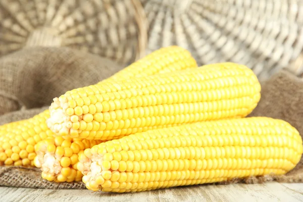 Crude corns on sackcloth on wooden table on wicker tray background — Stock Photo, Image