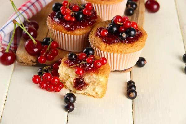 Muffin saporiti con bacche su tavolo di legno bianco — Foto Stock