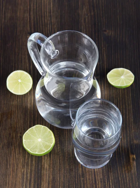 Glass pitcher of water and glass on wooden table close-up — Stock Photo, Image