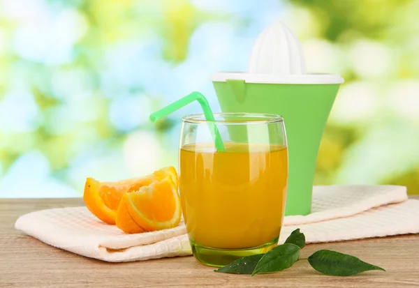 Glas juice, Citruspress och mogen orange på brun träbord — Stockfoto