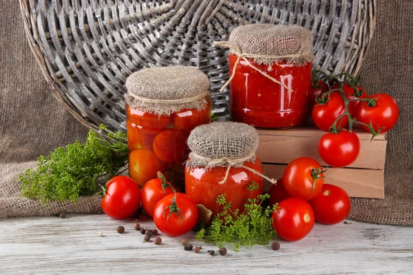 Sabrosos tomates enlatados y frescos sobre mesa de madera —  Fotos de Stock