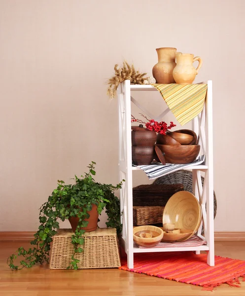 Schöne weiße Regale mit Geschirr und Dekor, auf farbigem Wandhintergrund — Stockfoto