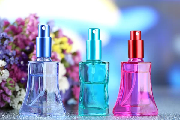 Perfume de mujer en hermosas botellas y flores —  Fotos de Stock