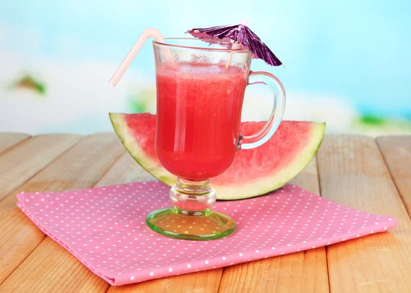 Copo de suco de melancia fresca, em mesa de madeira, sobre fundo brilhante — Fotografia de Stock