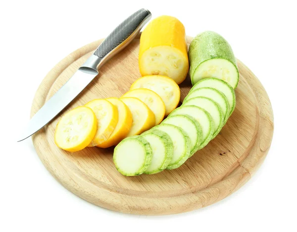 In Scheiben geschnittene und ganze rohe Zucchini auf Holzschneidebrett, isoliert auf weiß — Stockfoto