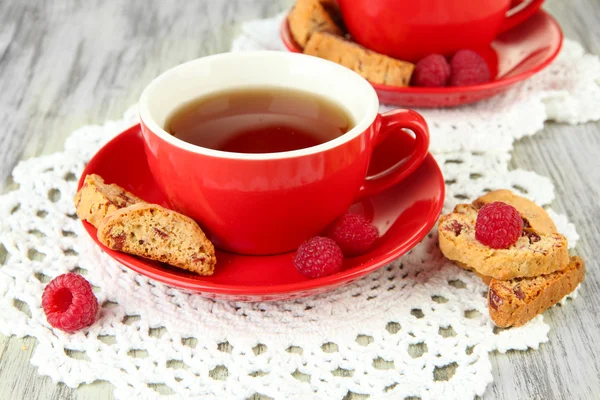 Tazas de té con galletas y frambuesas en primer plano de la mesa — Foto de Stock