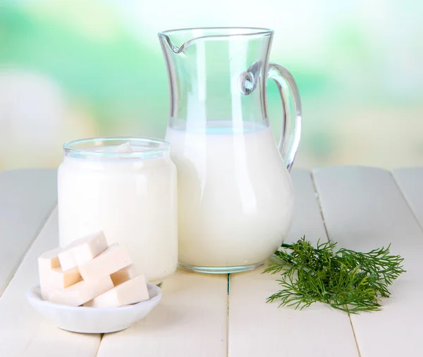 Fresh dairy products on wooden table on natural background — Stock Photo, Image
