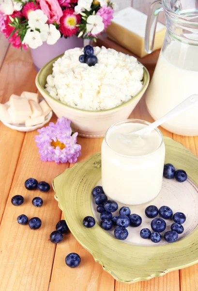 Frische Milchprodukte mit Blaubeeren auf Holztisch in Großaufnahme — Stockfoto