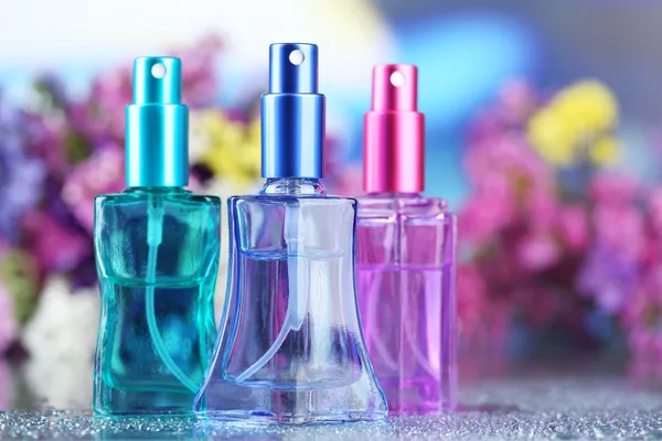 Perfumy kobiety w pięknych butelkach i kwiaty — Zdjęcie stockowe