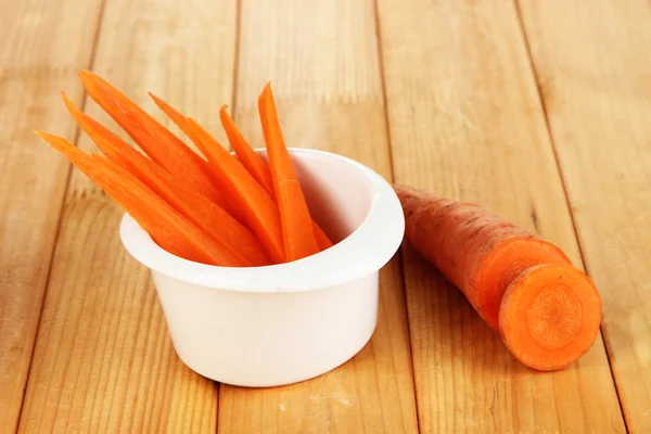 Φωτεινό φρέσκα καρότα, κόψτε επάνω τις φέτες σε μπολ σε κοντινό πλάνο ξύλινο τραπέζι — Φωτογραφία Αρχείου