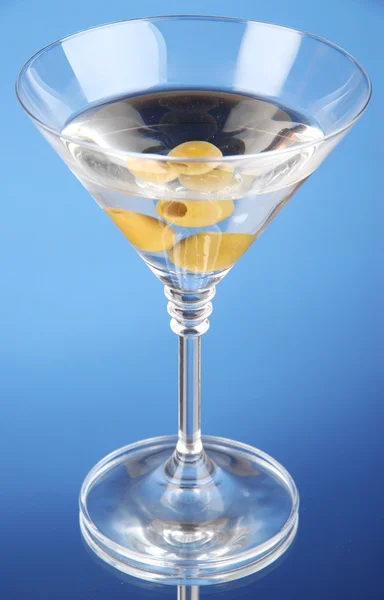 Martini s zelenými olivami na modrém pozadí — Stock fotografie