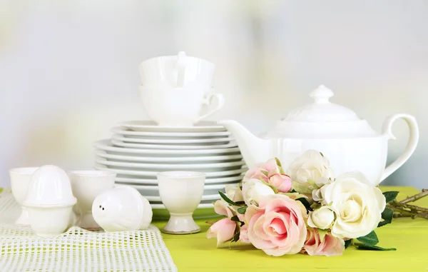 Lots beautiful dishes on wooden table on bright background — Stock Photo, Image