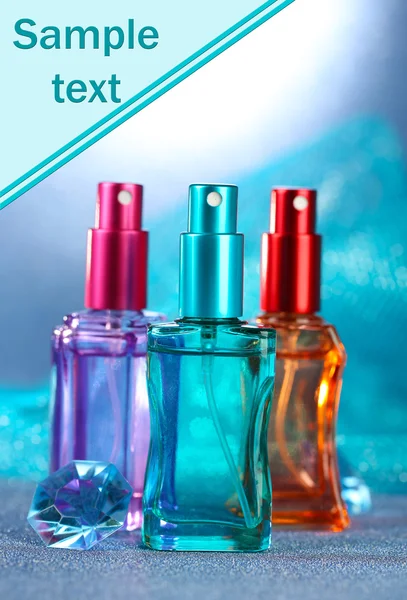 Femmes parfum dans de belles bouteilles sur fond bleu — Photo