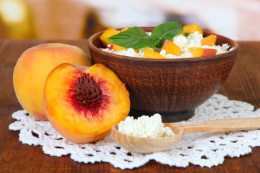 ekşi peynir ve taze şeftali, parlak zemin üzerine ahşap masa üzerinde parçaları