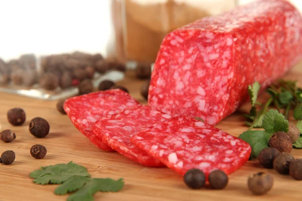 Tasty salami on wooden board isolated on white — Stock Photo, Image