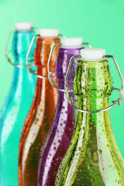 Bouteilles colorées sur fond vert — Photo