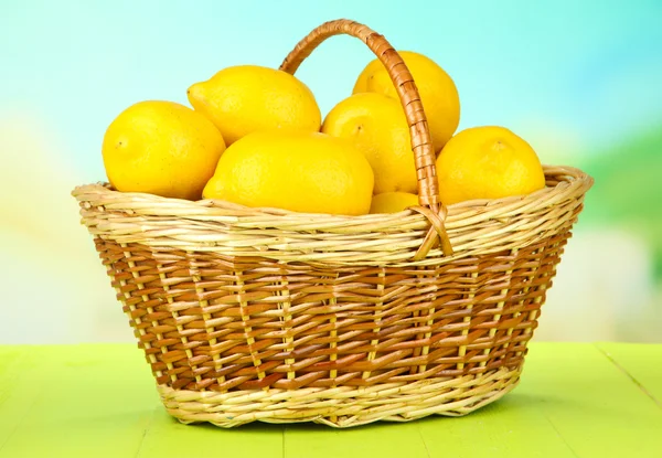 Ripe lemons in wicker basket on table on bright background — Stock Photo, Image