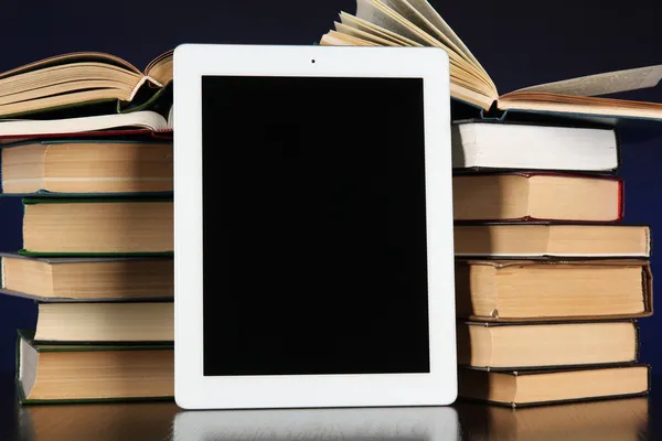 Tablette et livres sur fond lumineux — Photo