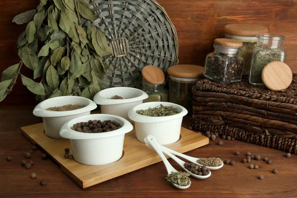 在白色的勺子和碗，木制背景上的香料的分类 — 图库照片