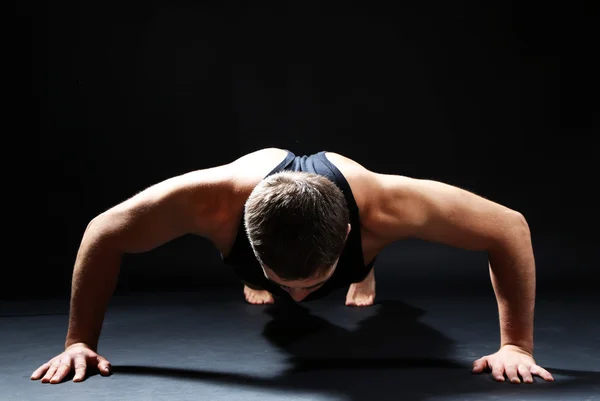 Guapo joven deportista muscular, sobre fondo oscuro — Foto de Stock