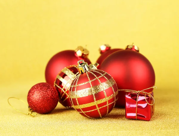 Christmas balls and small gift on yellow background — Stock Photo, Image