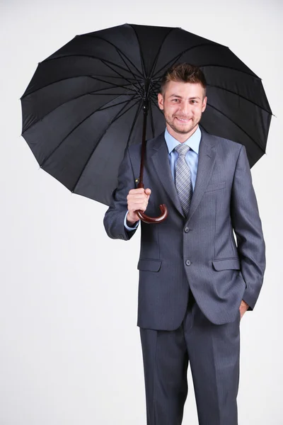 Empresário com guarda-chuva. sobre fundo cinza — Fotografia de Stock