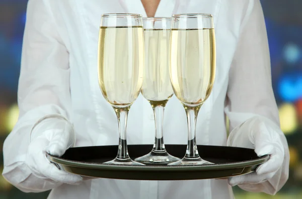 Официантки держат поднос с бокалами шампанского — стоковое фото