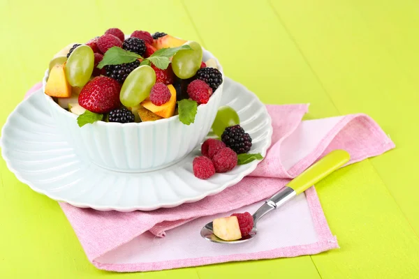 Fruit salad in bowl, on wooden background — Stock Photo, Image