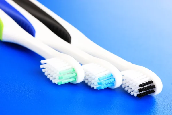 Tooth-brushes on blue background — Stock Photo, Image