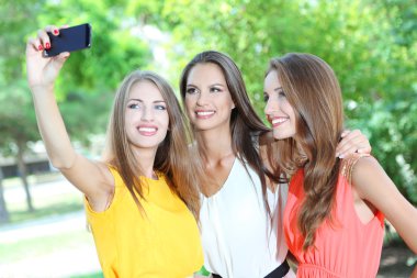 Üç güzel genç kadın alarak resim yaz Park