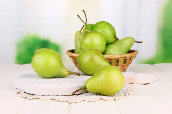 Pears on wooden cutting board, on light background — Stock Photo, Image