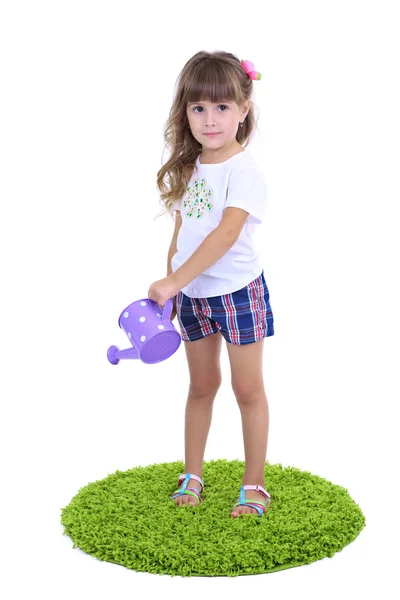 Маленькая девочка поливает зеленую траву, изолированную на белом — стоковое фото