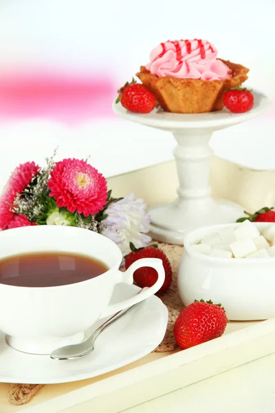 Cup of tea with cakes on wooden tray on table in room — Stock Photo, Image