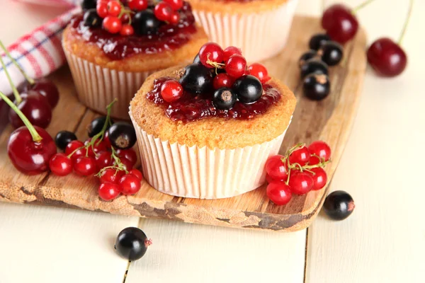 Muffin saporiti con bacche su tavolo di legno bianco — Foto Stock