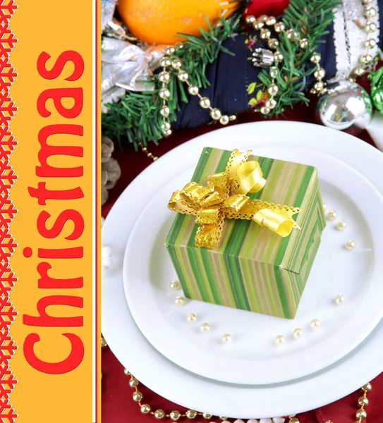 Pequeño regalo de Navidad en el plato al servir la mesa de Navidad de cerca —  Fotos de Stock