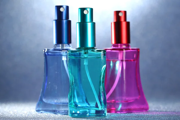 Güzel şişelerde parlak zemin üzerine kadın parfüm — Stok fotoğraf