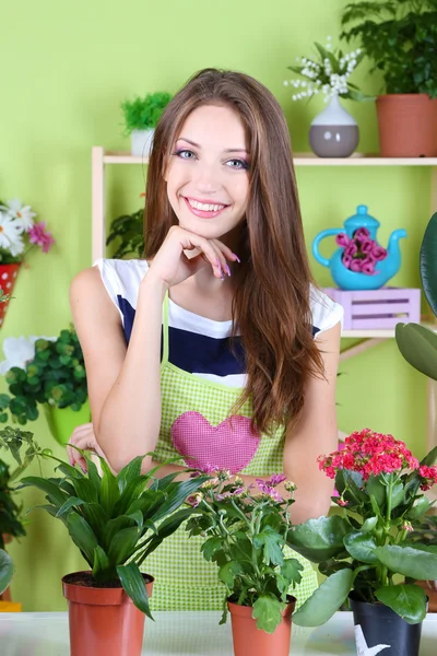 Beautiful girl florist with flowers in room — Stock Photo, Image