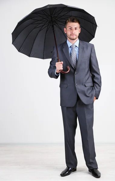 Uomo d'affari con ombrello. su sfondo grigio — Foto Stock