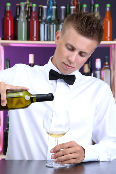 Bartender is pouring white wine into glass — Stock Photo, Image