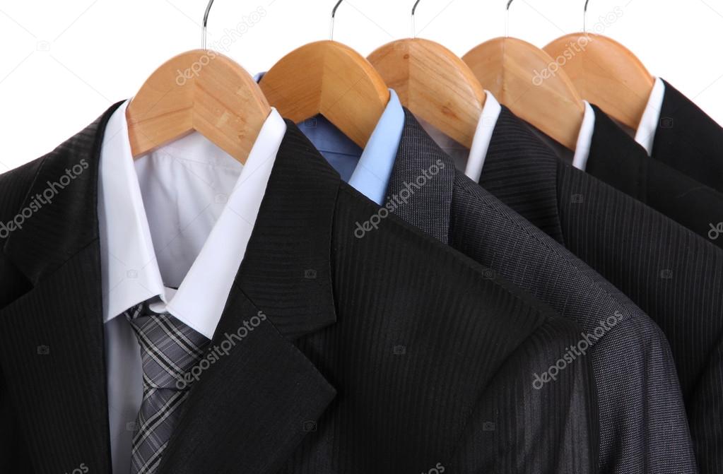 Suits with shirts on hangers on white background