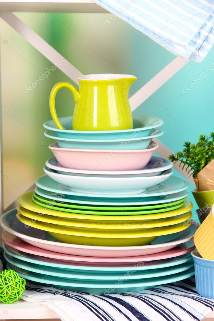 Beautiful white shelves with tableware and decor, on bright background, close-up