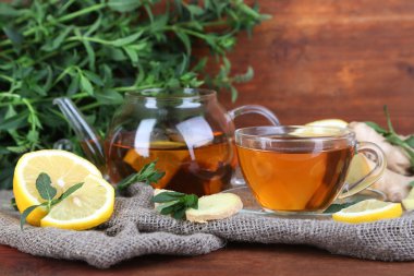 Kettle ve çay zencefil üzerinde parlak zemin üzerine ahşap masa üstünde çul ile