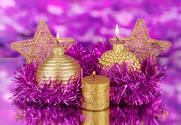 Χριστούγεννα σύνθεσης με κεριά και διακοσμήσεις σε πορφυρά και χρυσά χρώματα σε φωτεινό φόντο — Φωτογραφία Αρχείου