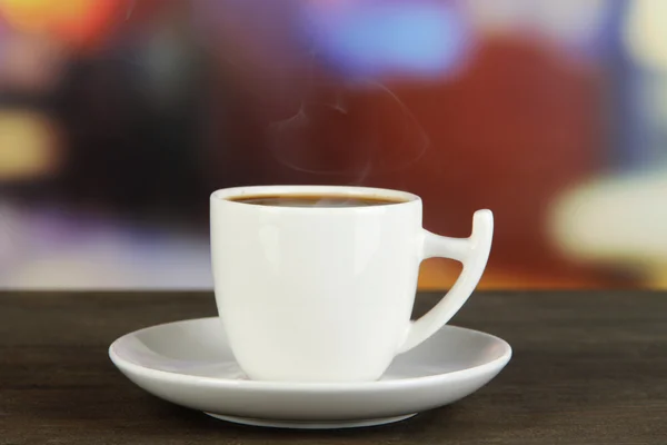 Taza de café sobre mesa de madera sobre fondo brillante —  Fotos de Stock